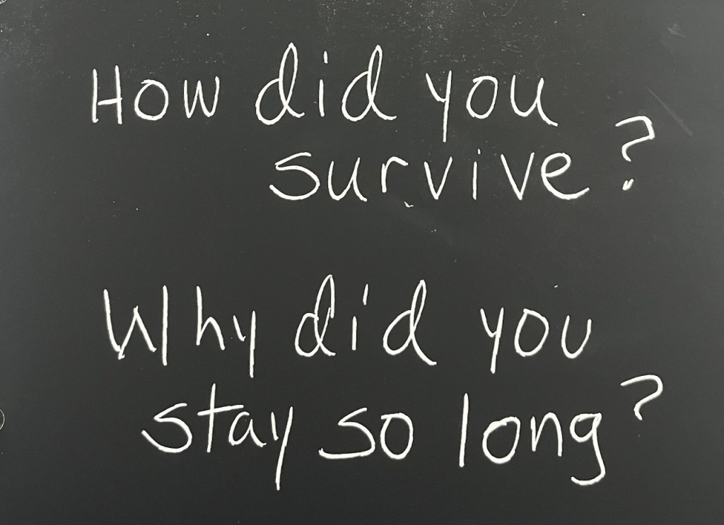 Two questions handwritten in white letters on a black background like chalk on a blackboard: How did you survive? and Why did you stay so long?